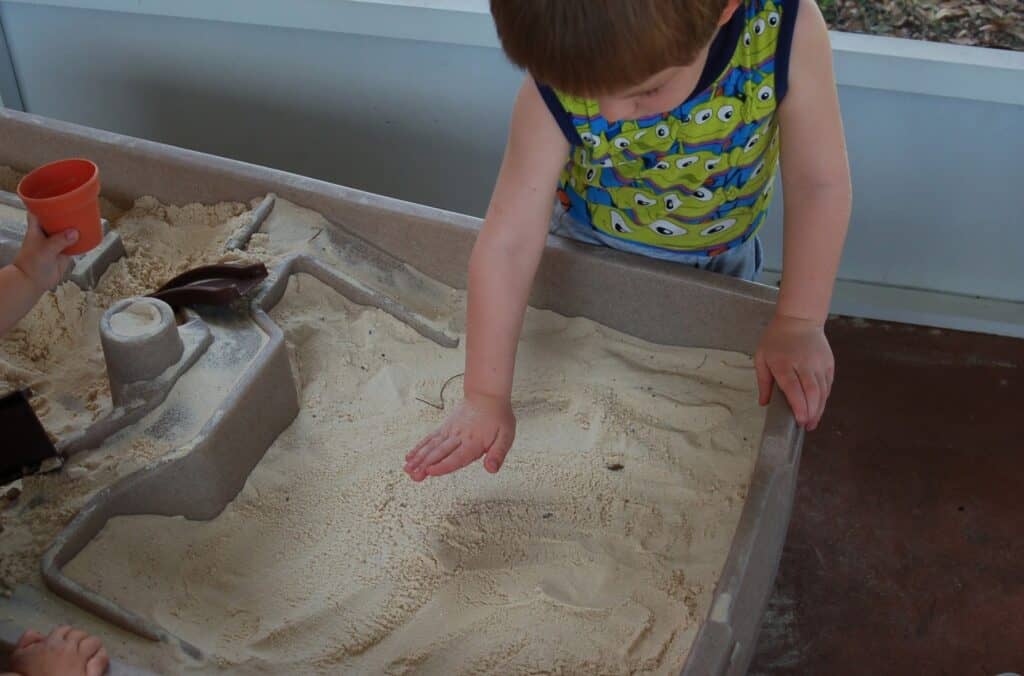 little boy playing in sand