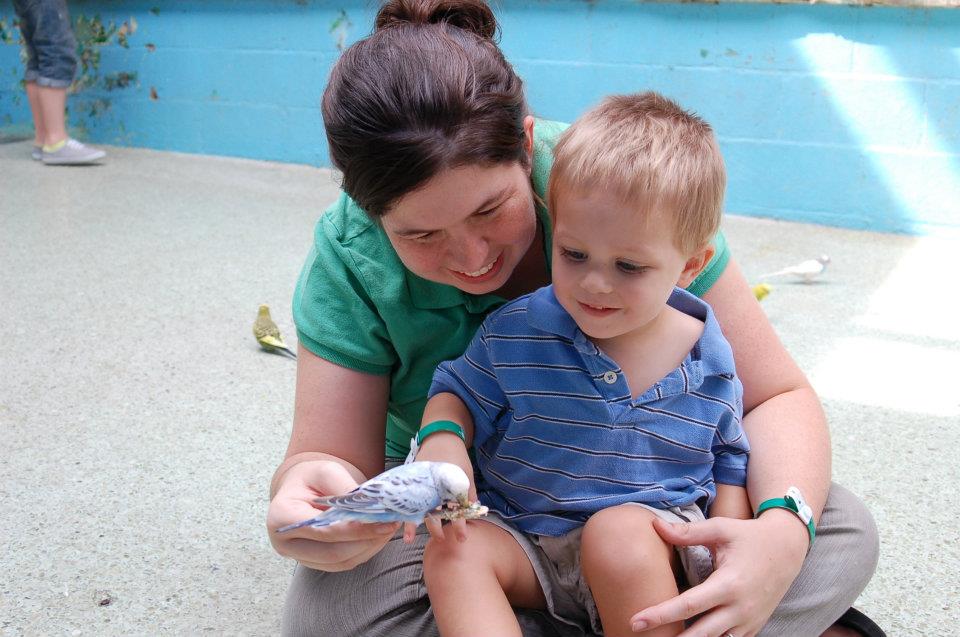 mom with toddler boy feeding birds