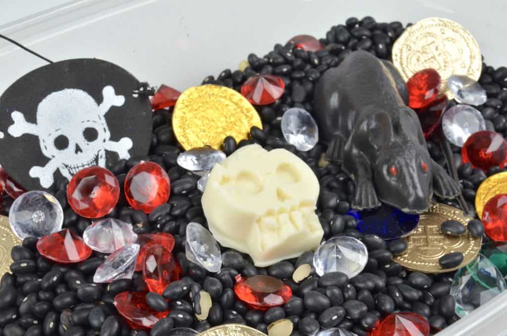 pirate themed sensory bin with black beans