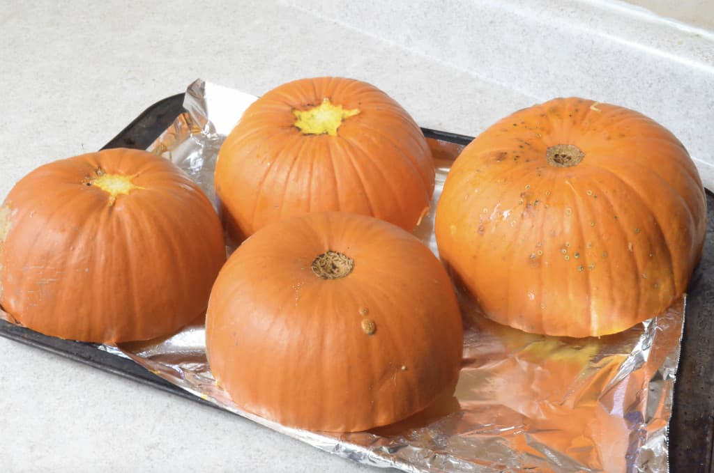 pumpkins cut in half on baking tray