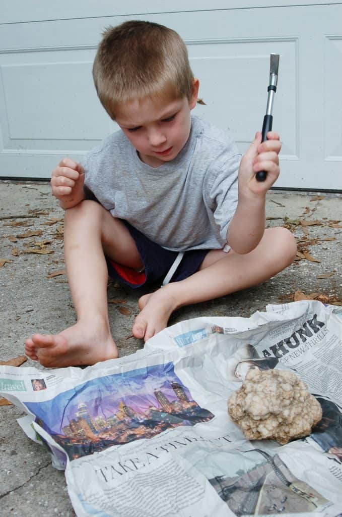 boy cracking geodes rocks
