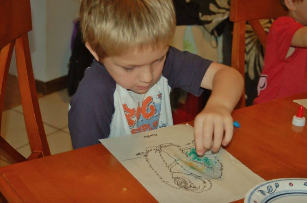 boy coloring with art sand