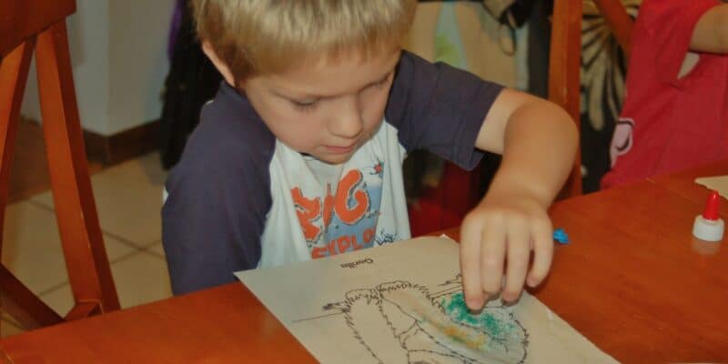 boy coloring with art sand