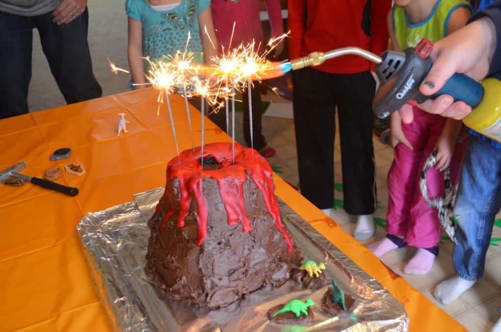 lighting sparklers on a dinosaur volcano cake tutorial