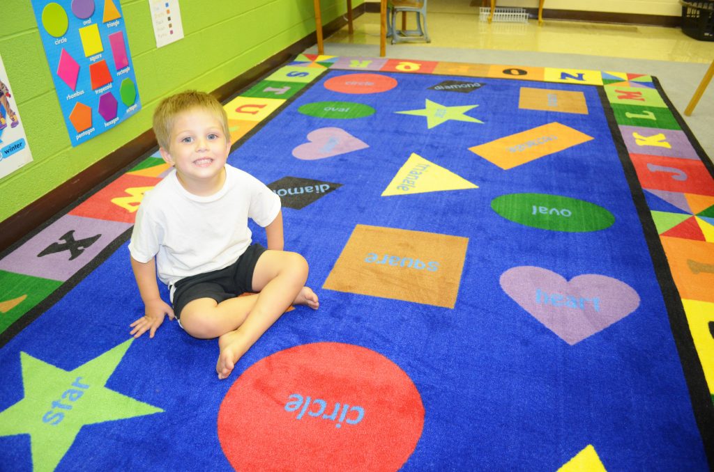 boy sitting on classroom rug