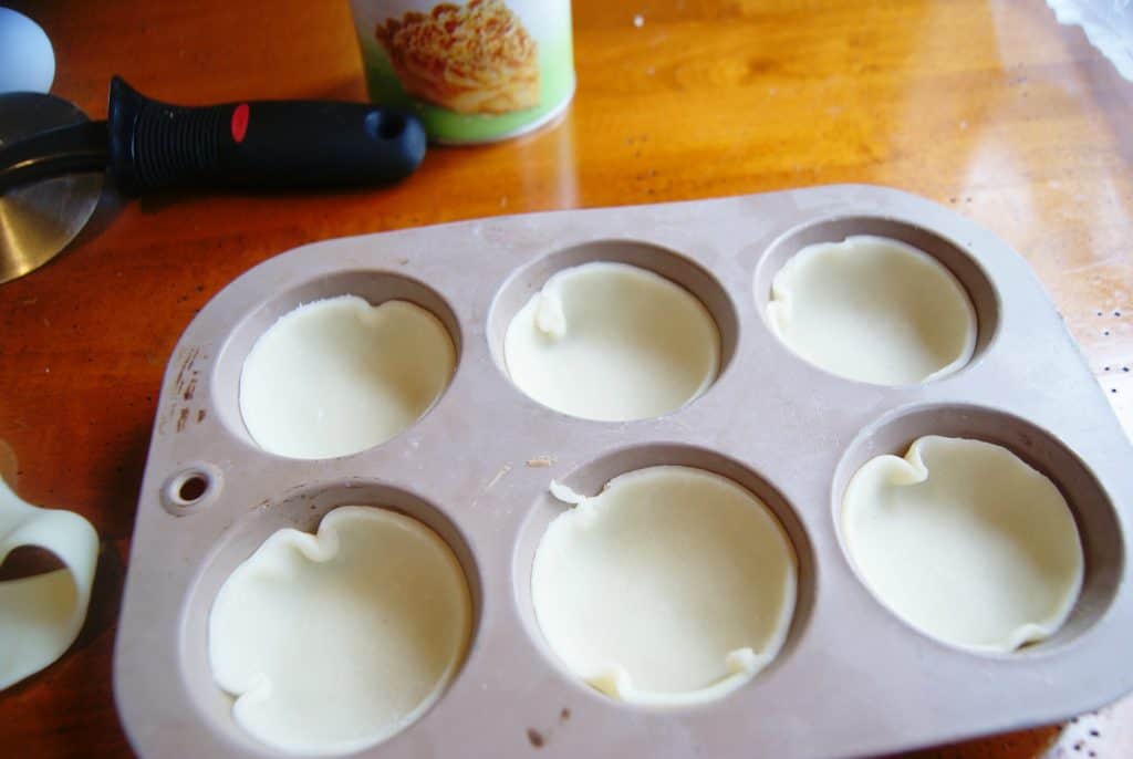 raw apple pie dough in muffin tin