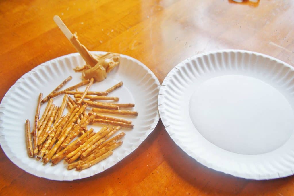 plate of pretzel sticks with peanut butter