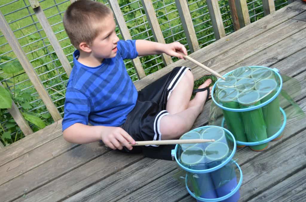 boy kid playing recycled drums