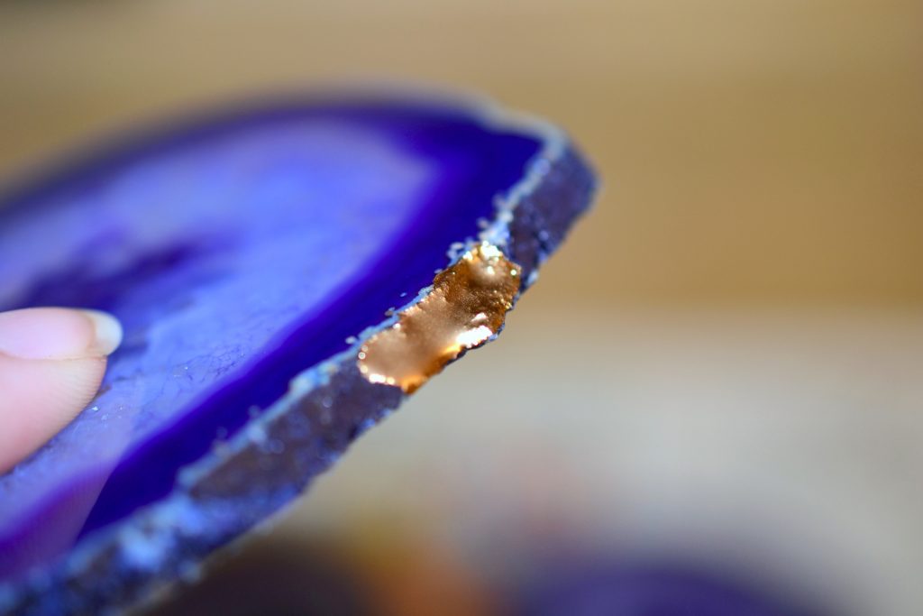 close up of agate slice edge with gold paint