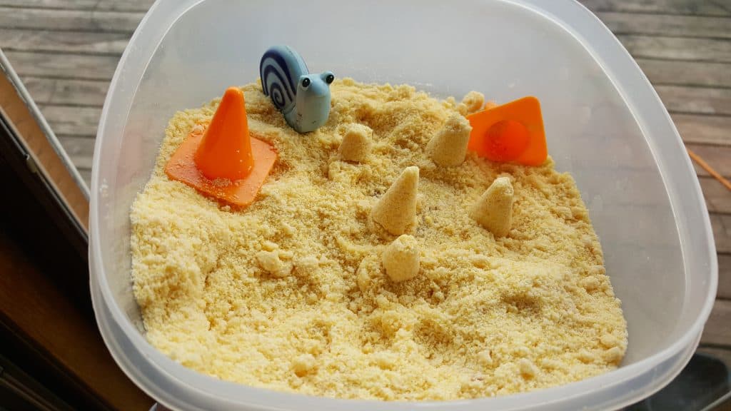 kinetic sand sensory bin with kid's toys 