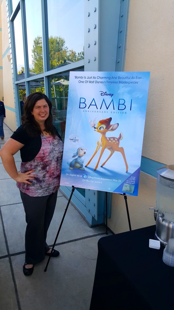 standing next to the Disney Bambi movie poster