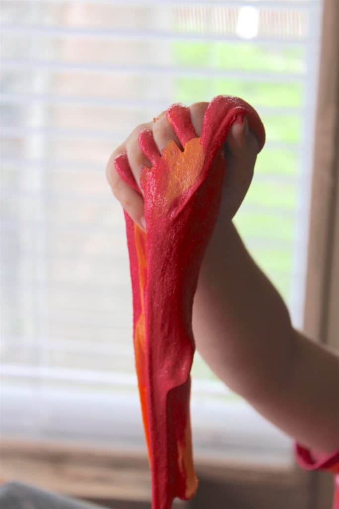 kid's hand holding stretchy lava slime