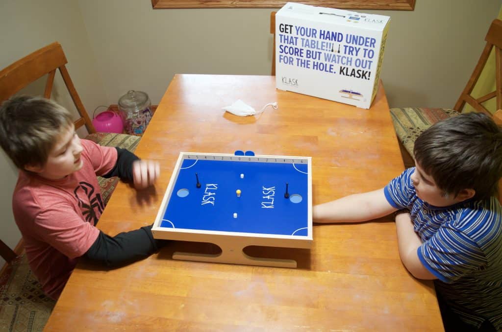 brothers playing Klask magnetic game