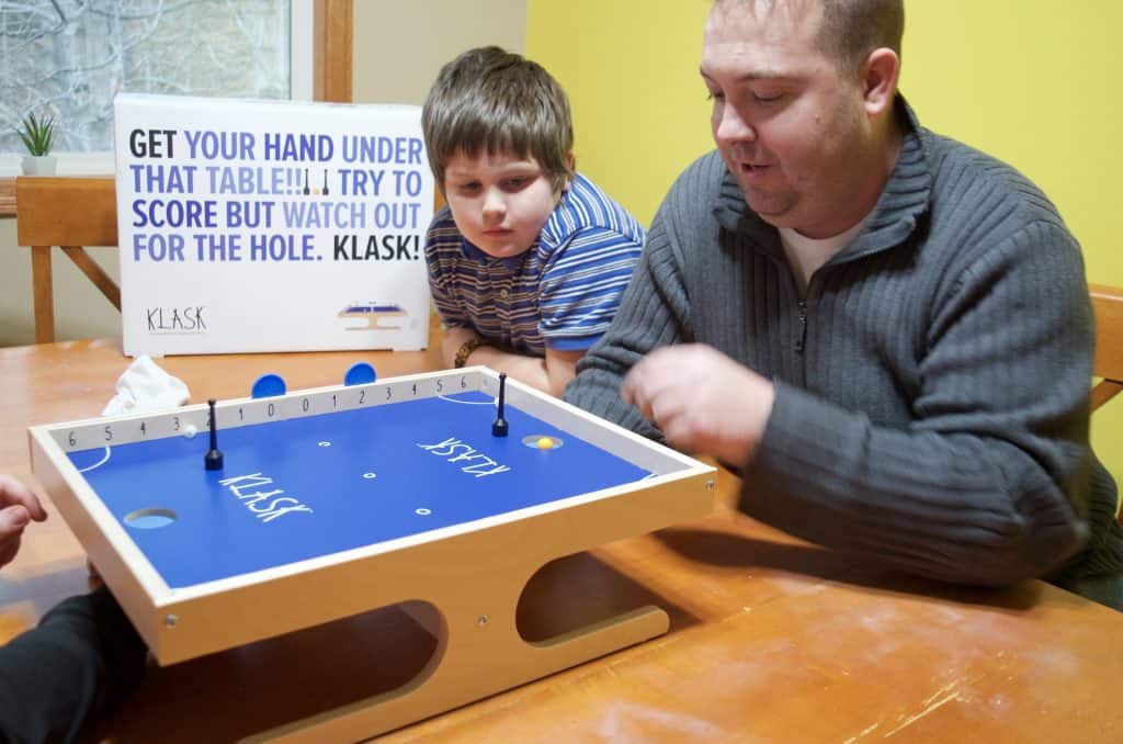 boys playing Klask with their father for game night
