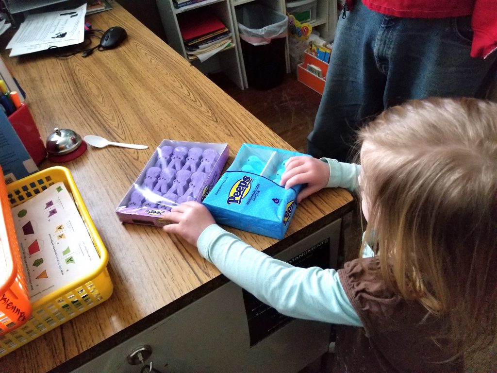 little girl putting PEEPS on desk