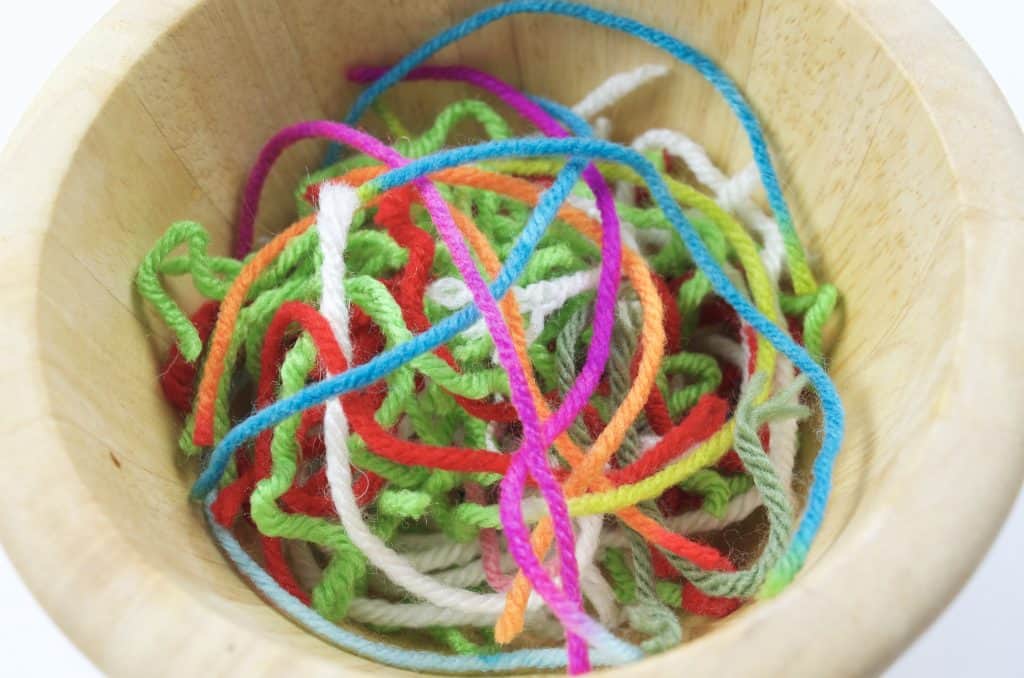 wooden bowl of yarn scraps for camping craft