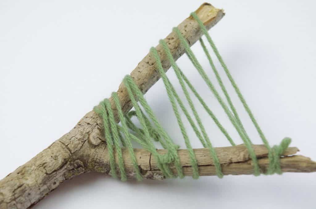 green yarn wrapped around stick camping craft