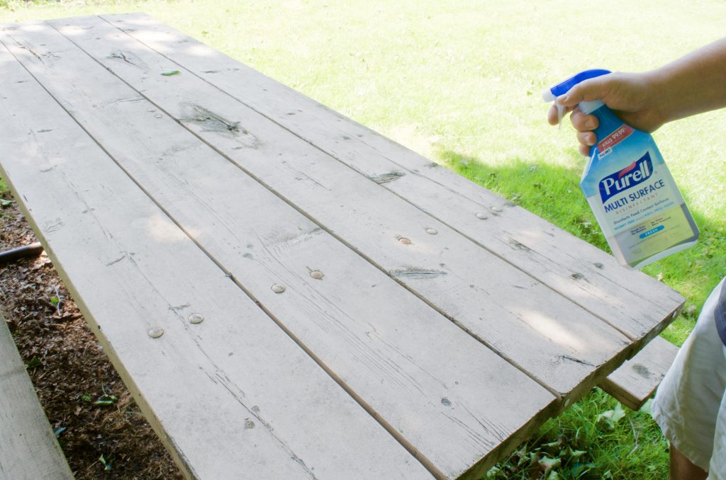 using PURELL Multi Surface Disinfectant on picnic table