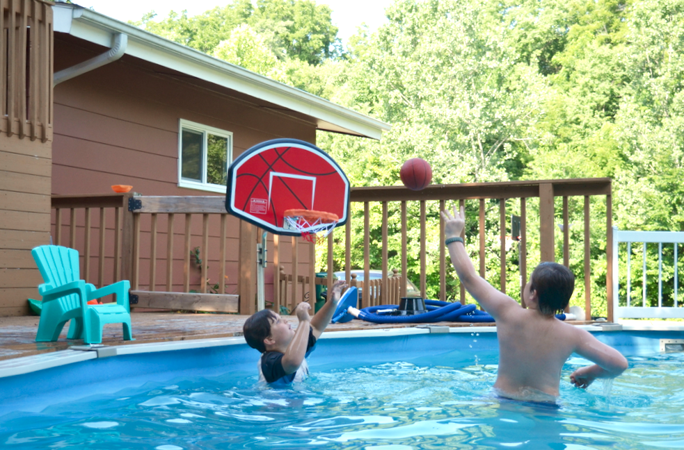 boys playing basketball in the pool