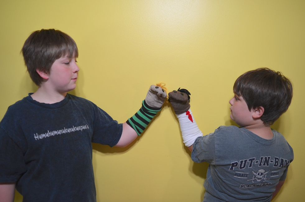 boys play sock puppet theater