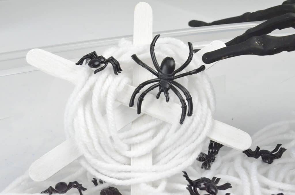white craft stick and yarn spider web craft