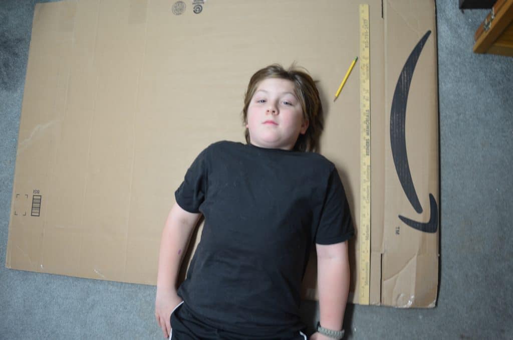 boy laying on cardboard box Amazon prime smile