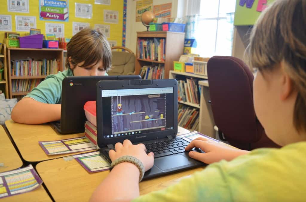 two boys students typing on computer