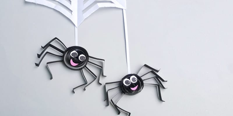 two paper quilled spiders on web