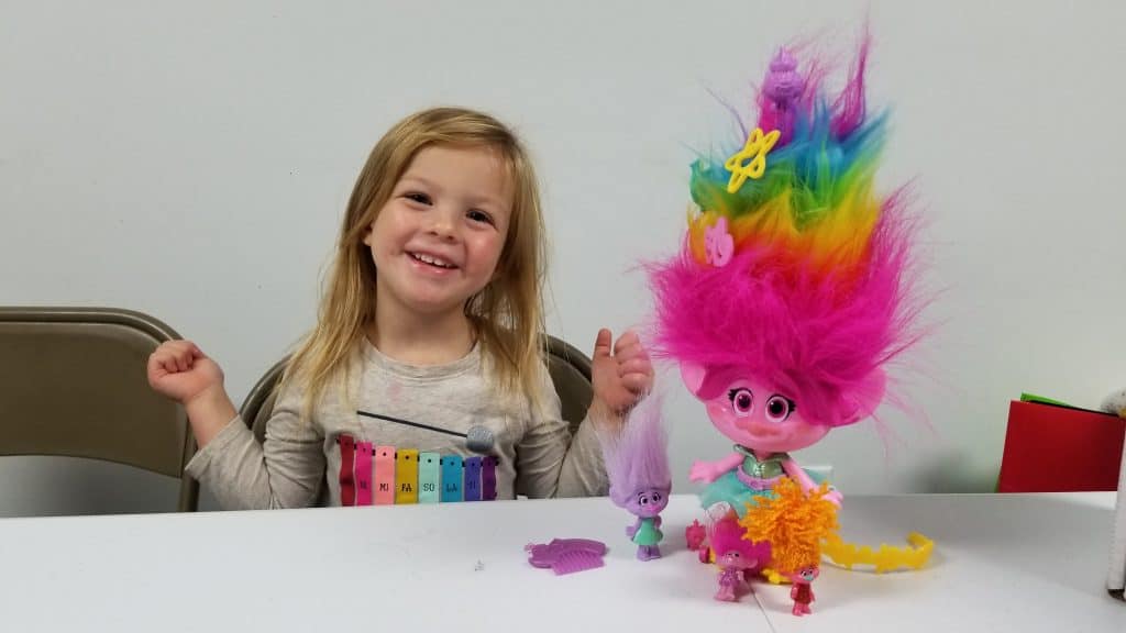 girl playing with DreamWorks Trolls toys