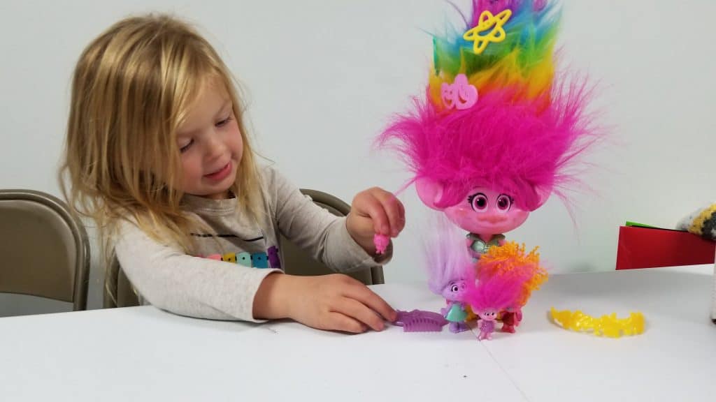 girl playing with DreamWorks Trolls toys