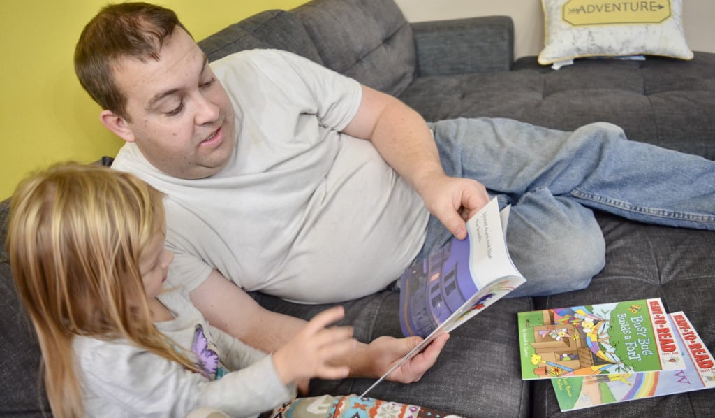 preschool girl reading books with dad