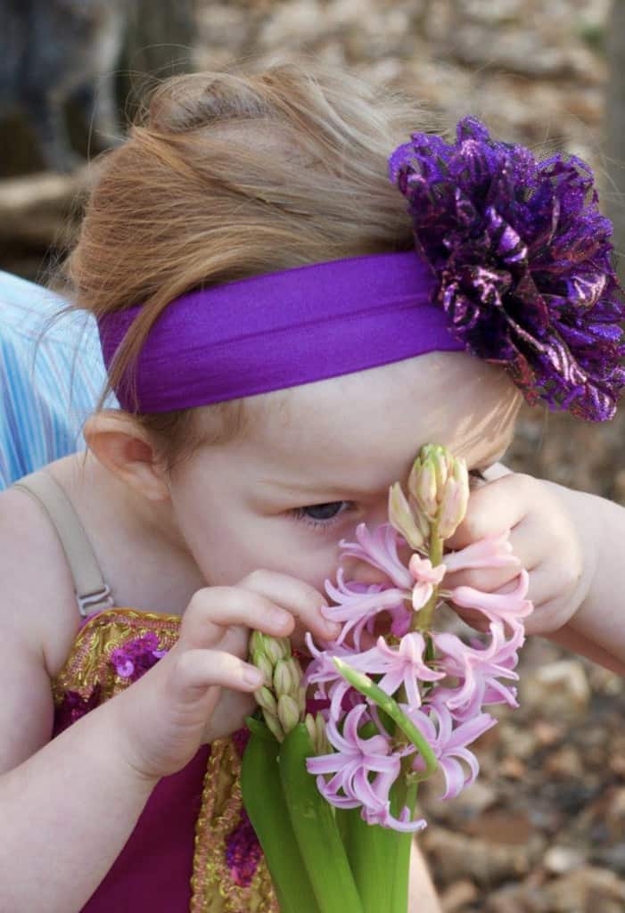 little girl smelling flowers