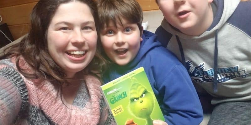 mom with two boys family holding The Grinch movie