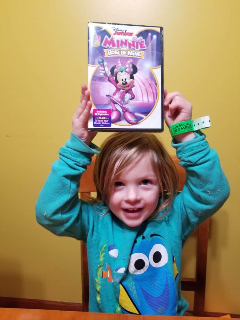 preschool girl holding Minnie Mouse DVD