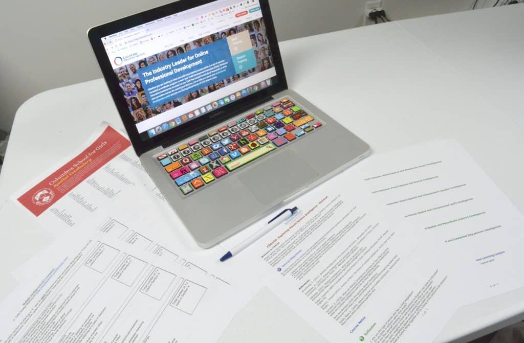 laptop with professional development handouts