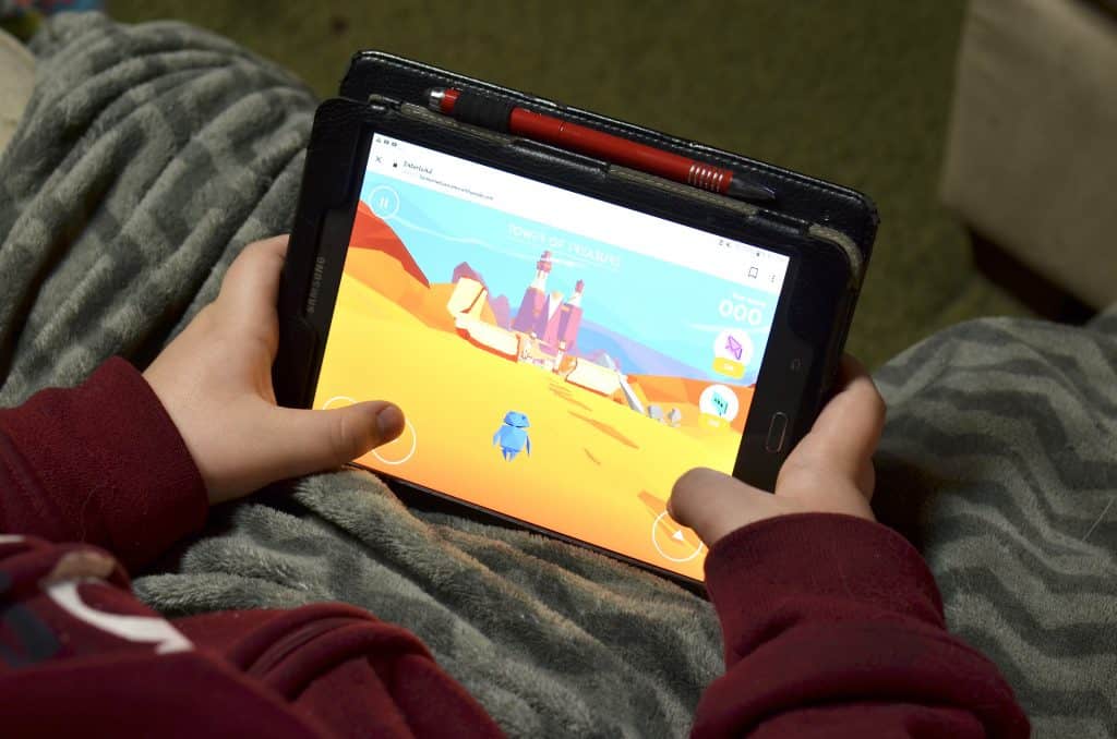 boy holding tablet playing game