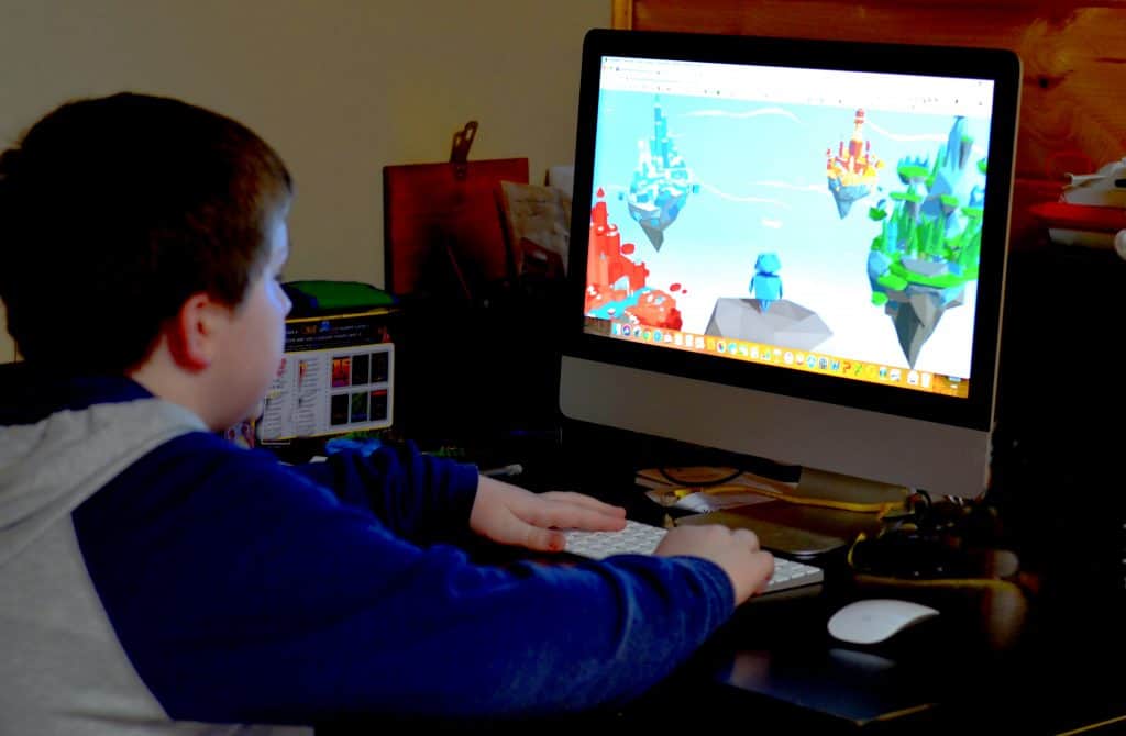 boy sitting at computer playing game