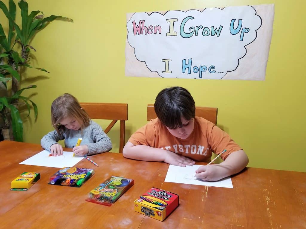 two kids drawing with art supplies