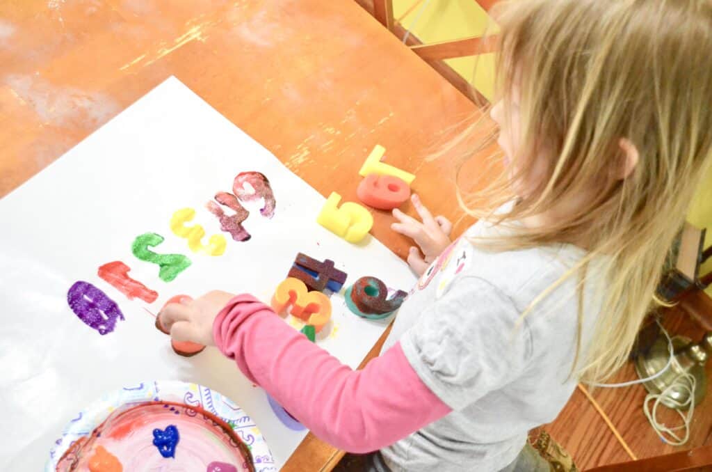 girl doing art letters and numbers