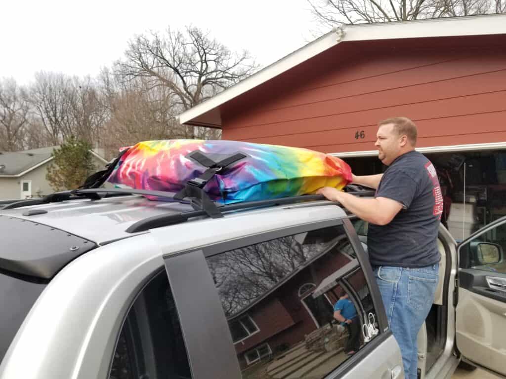 man installing car top carrier