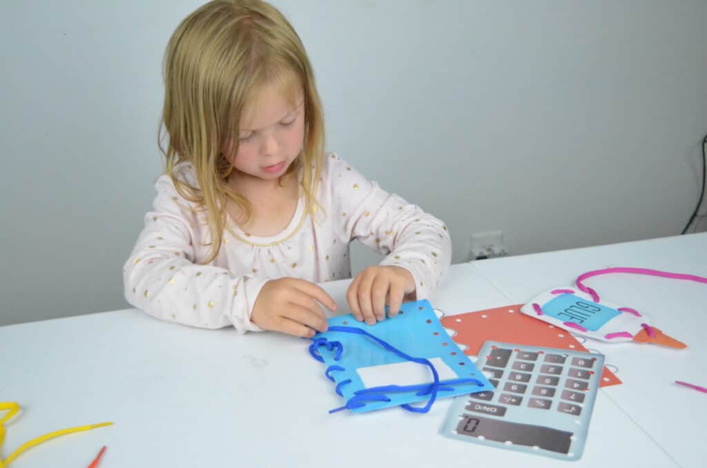 preschool girl lacing cards activity