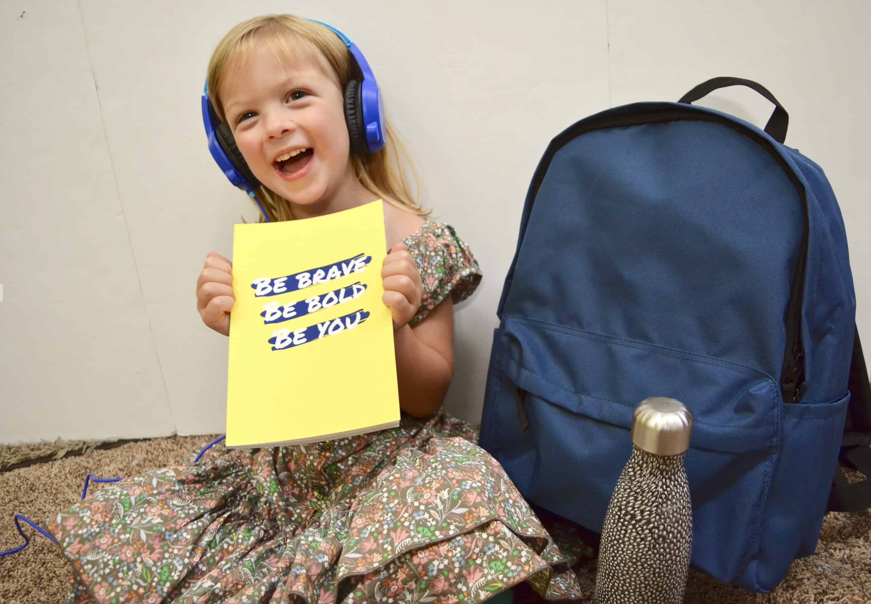 preschool girl with headphones school supplies