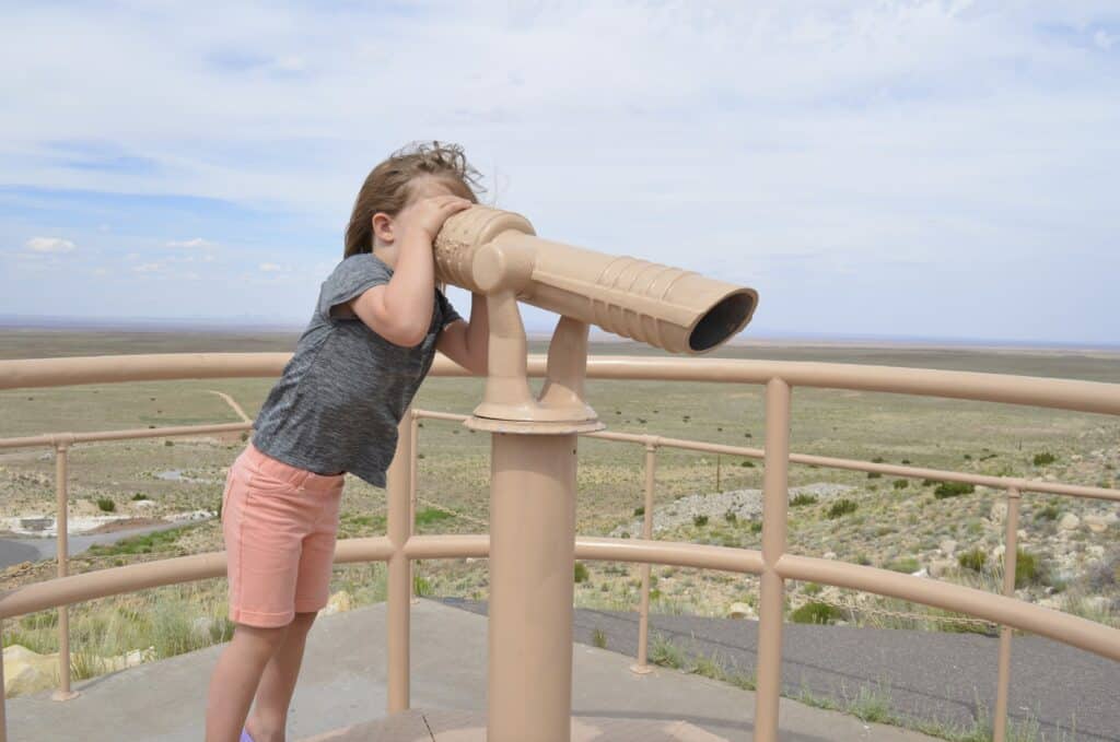 little girl looking through telescope