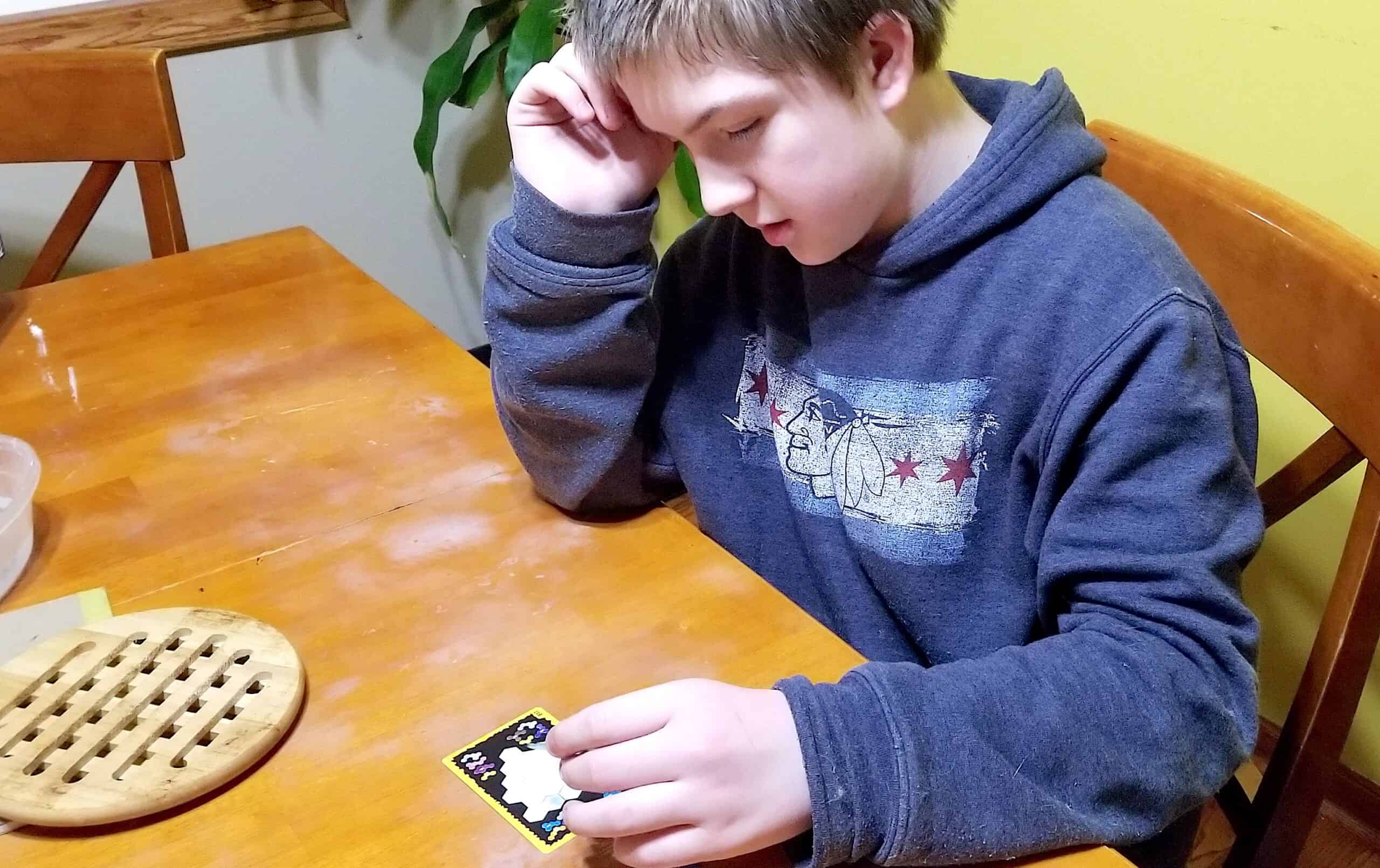 teen boy playing math game Ubongo Extreme