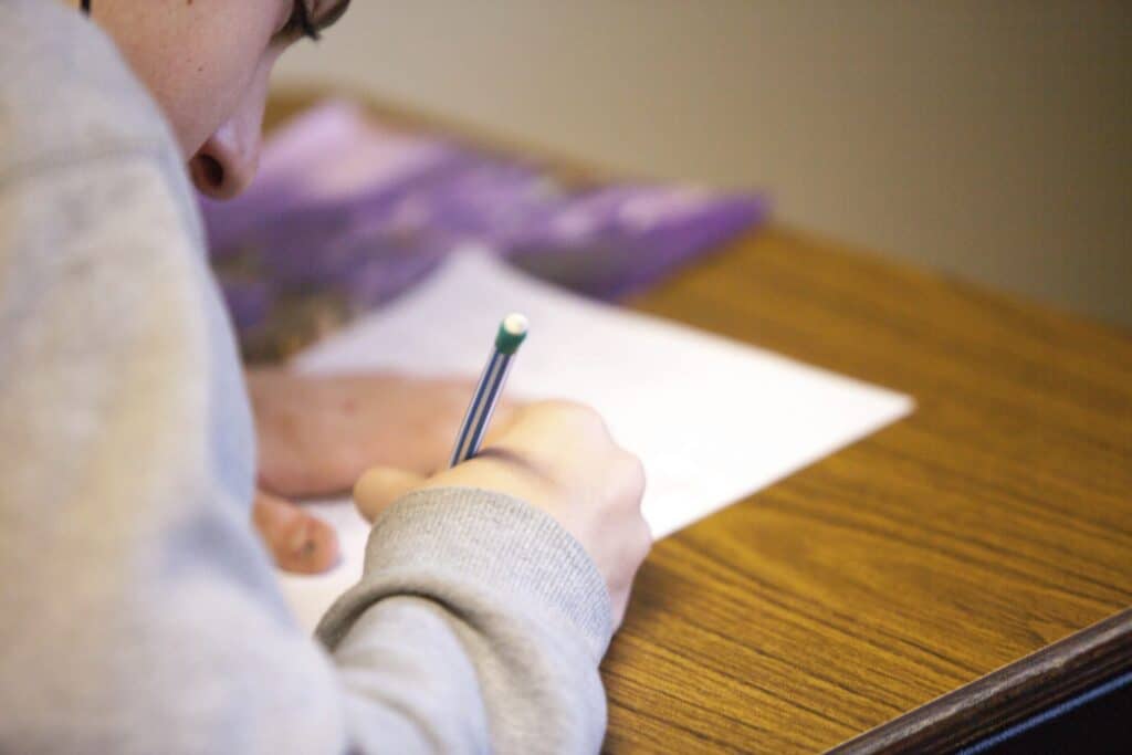 man writing at desk