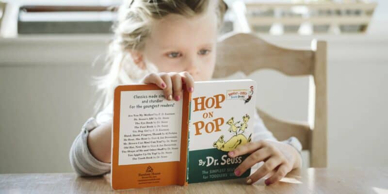 girl reading Dr Seuss book