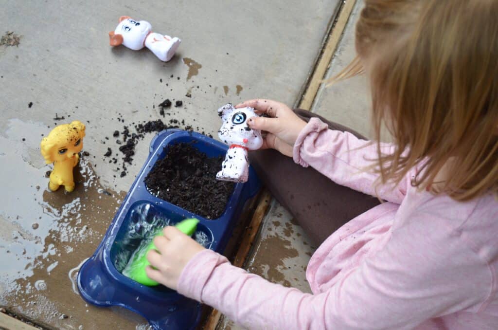 preschool girl washing dog sensory bin