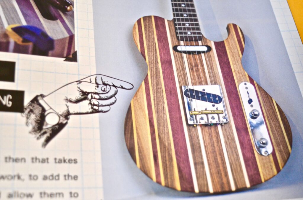 hand pointing to a guitar in a book