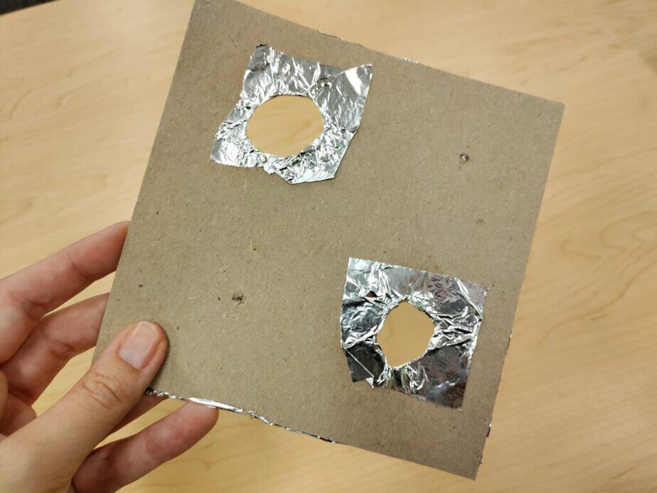 cardboard square with foil cut outs