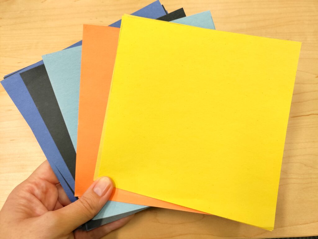 hand holding construction paper squares